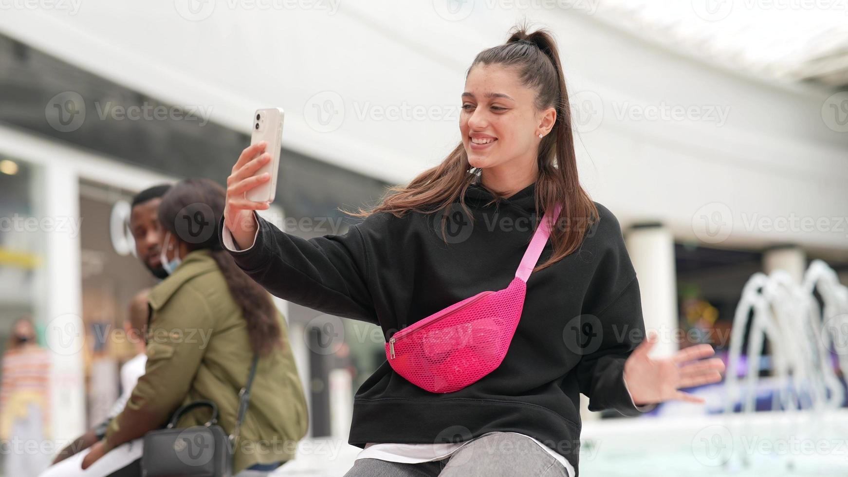 Woman using smartphone indoor. Texting and communicating in mall photo