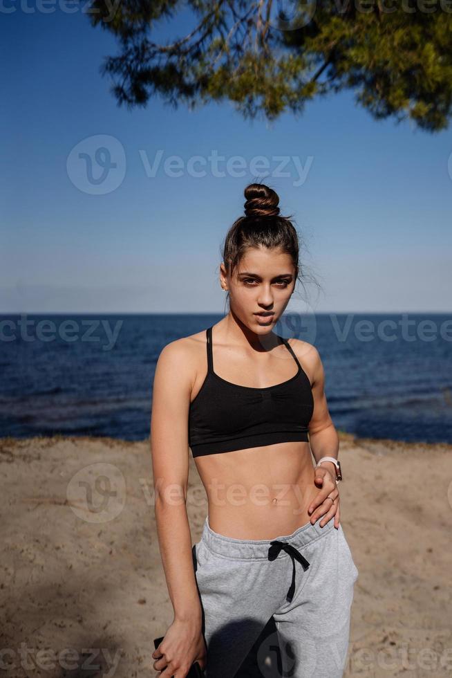 Fitness young woman walks in the park and posing for the camera photo