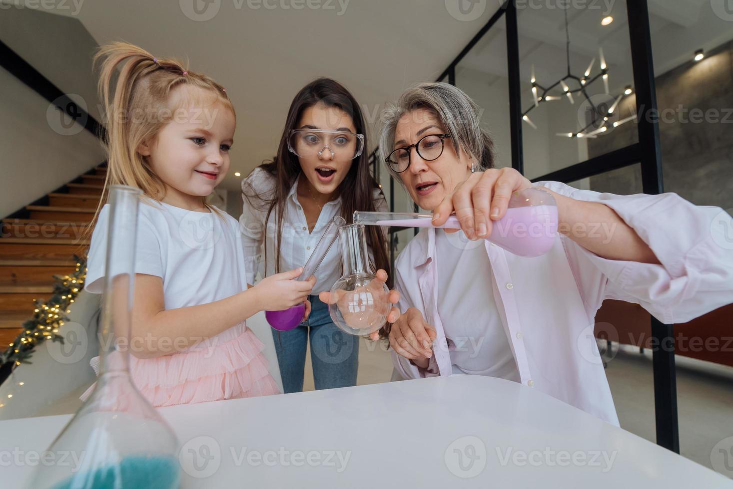 Family doing chemical experiment, mixing flasks indoors photo