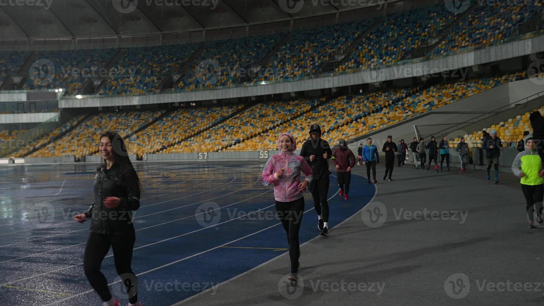 People go in for sports at night stadium in rainy weather photo