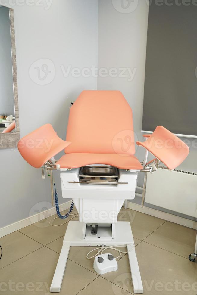 A gynecological chair standing in the center of the room in clinic. Pregnancy. Preventive medicine photo