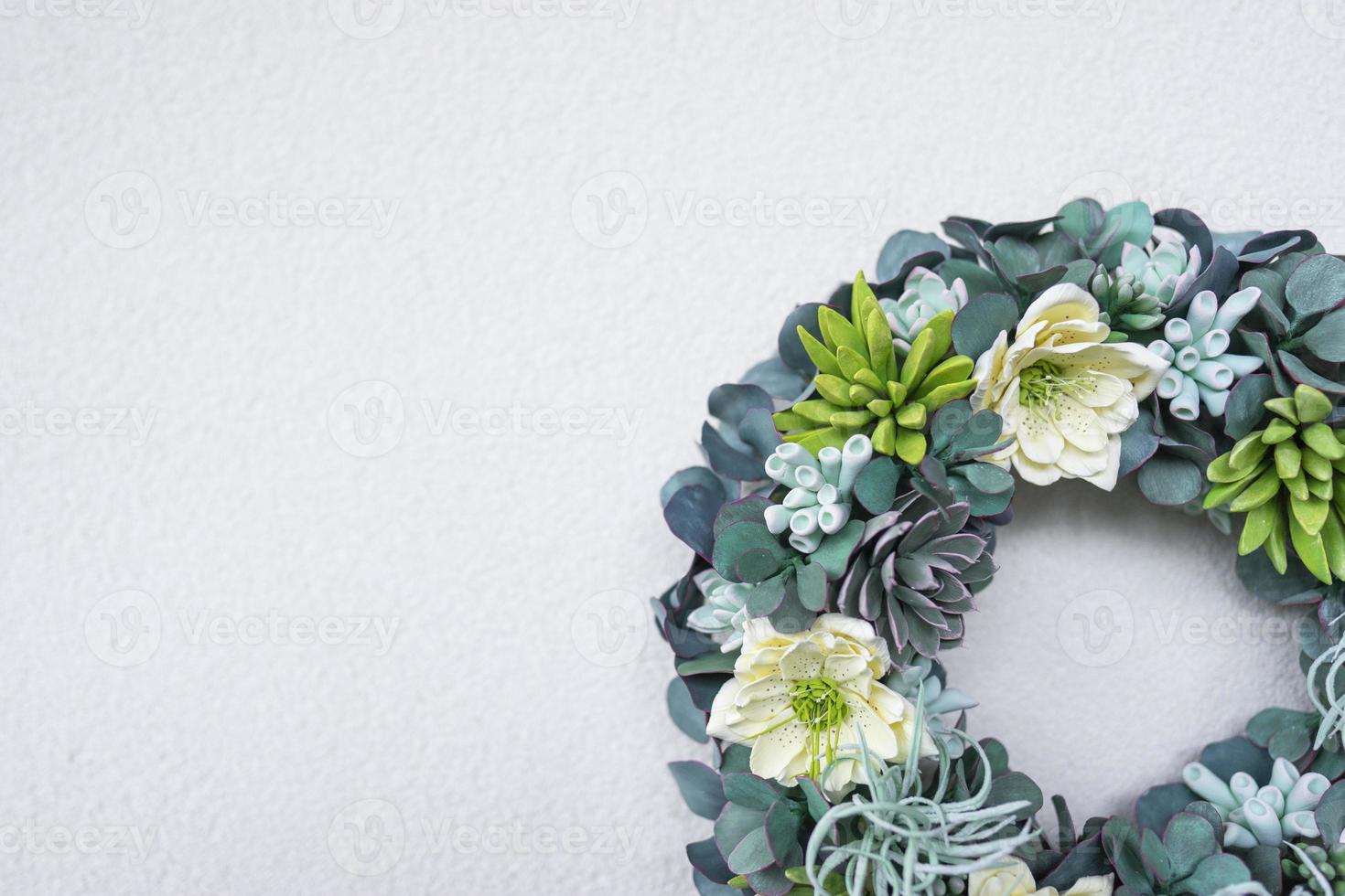 A wreath made of succulent plants decorates the interior of the modern apartment with a textured wall background photo