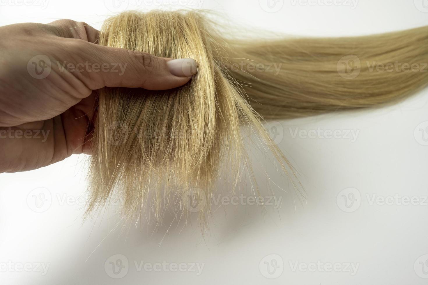 una mujer con una capa de pelo rubio en la mano foto