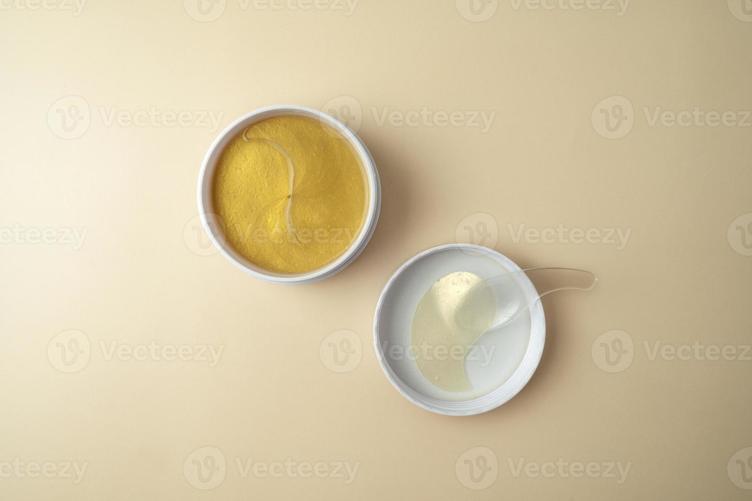 Golden antiaging eye patches with the snail extract lying on a beige background photo