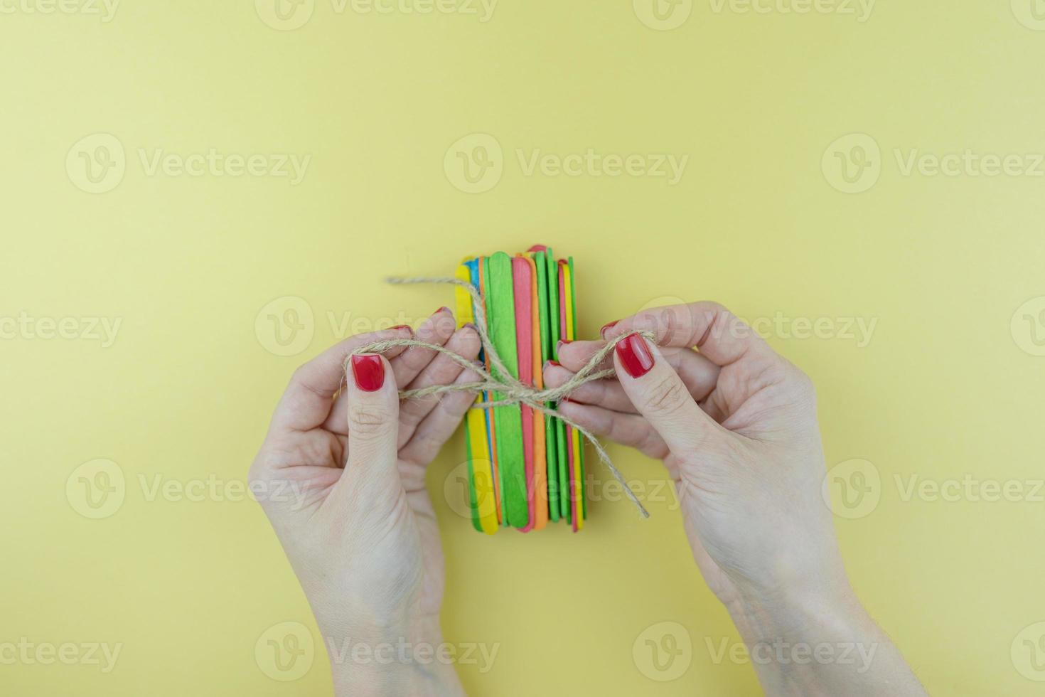 una mujer ata un montón de palos de colores foto