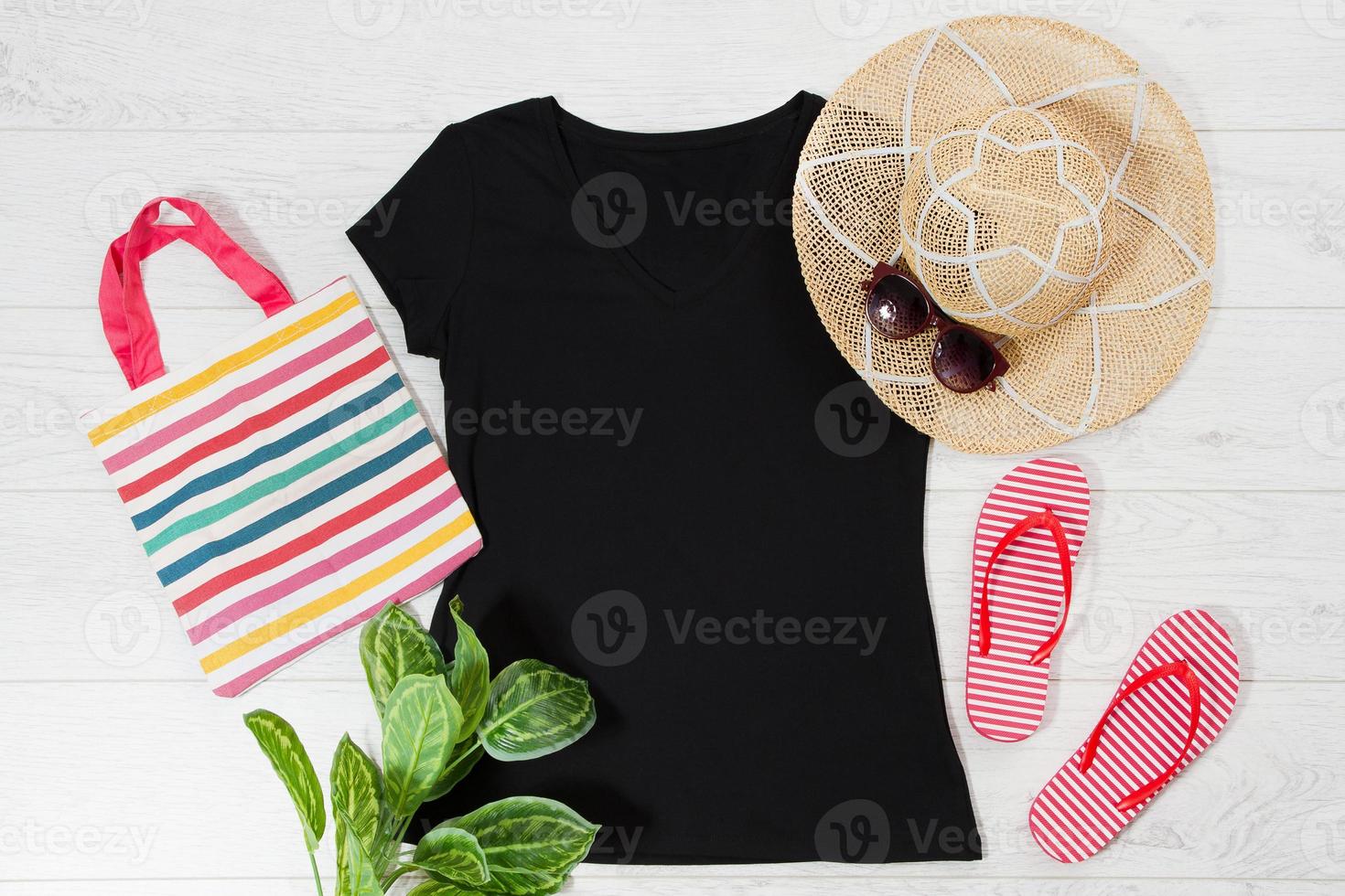 T shirt black and slippers. T-shirt Mockup flat lay with summer accessories. Hat, bag, red flip flops and sunglasses on wooden floor background. Copy space. Template blank canvas. Front top view. photo
