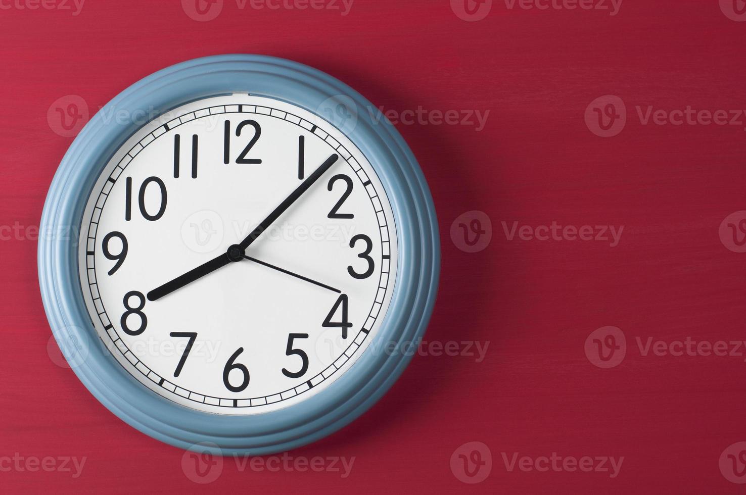 Blue wall clock on red grunge background. photo