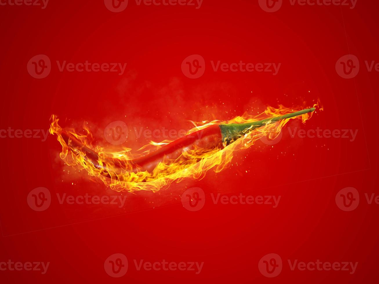 fresh red chilli, on fire on red background photo