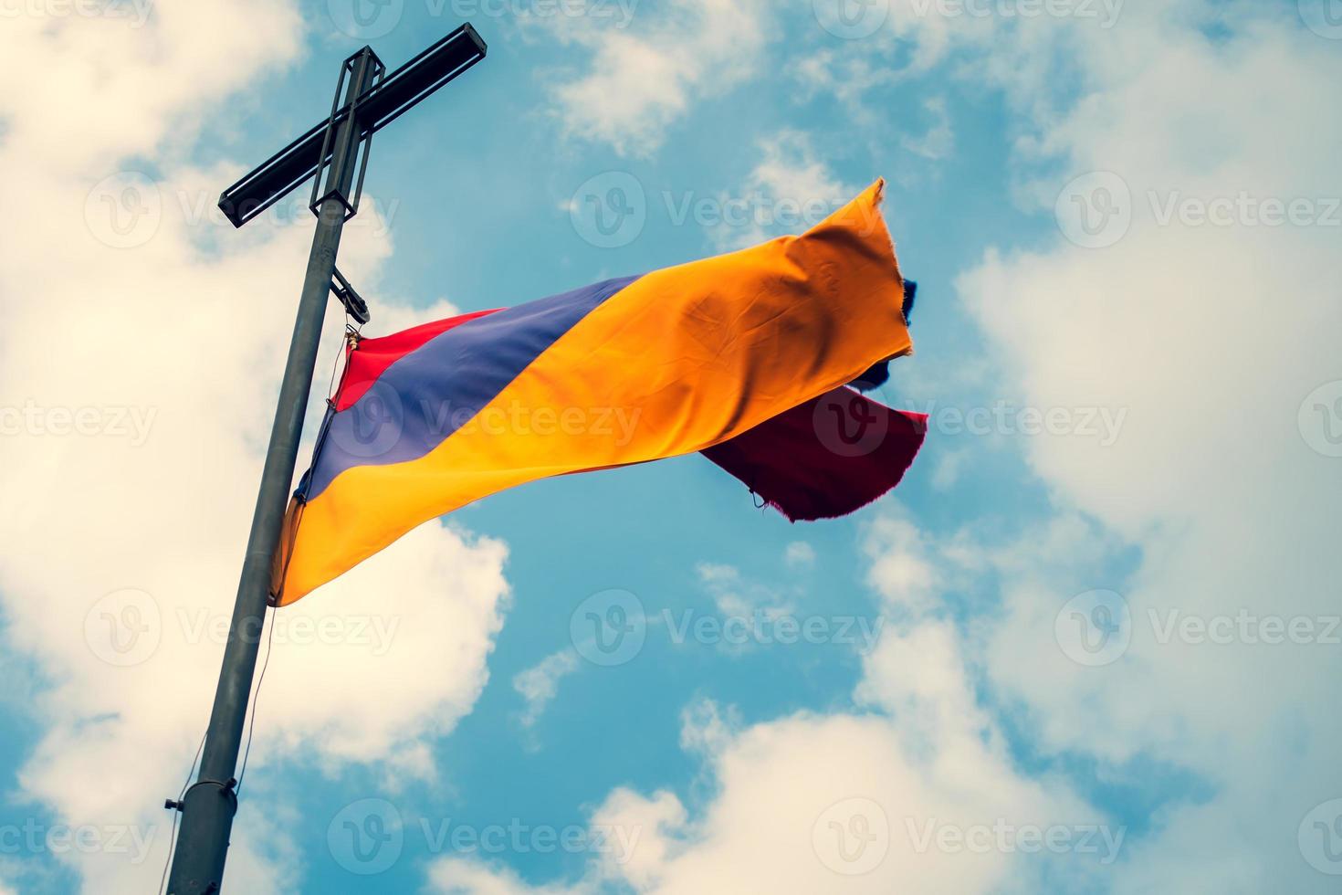 National Armenia symbol - armenian flag on post on hill top with sunny sky background. Dramatic copy space cloudscape view photo