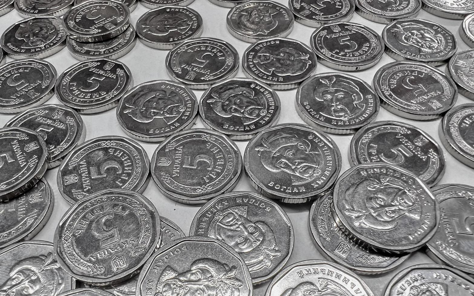 monedas metálicas de cinco hryvnia sobre una superficie blanca. dinero ucraniano. foto