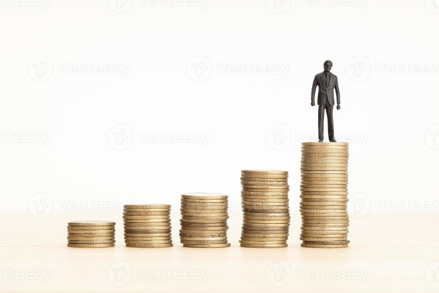 Wealth growth process concept. Man figurine on Rising Coin stacks. Copy space photo