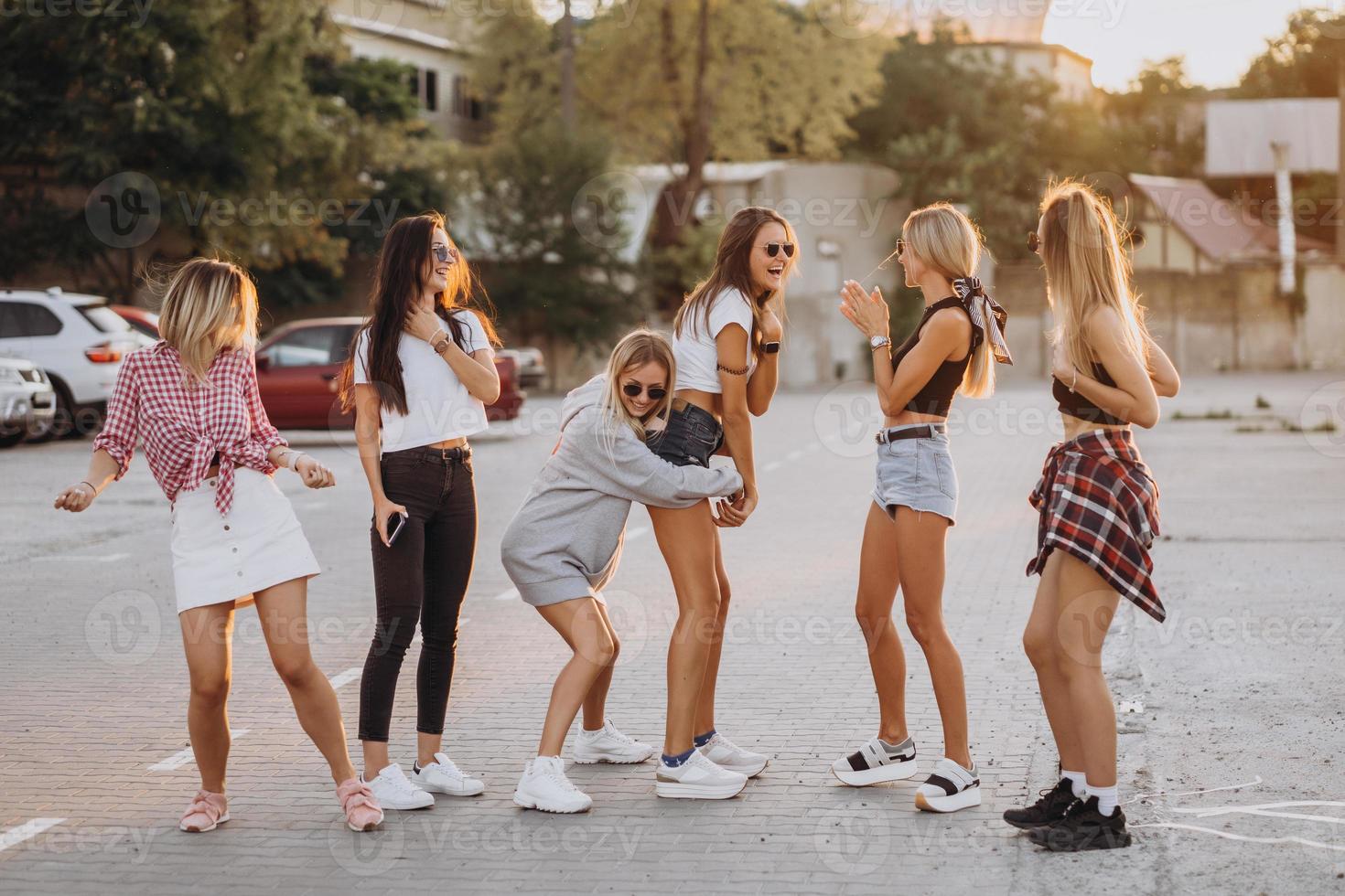 Six young women dance in a car park photo