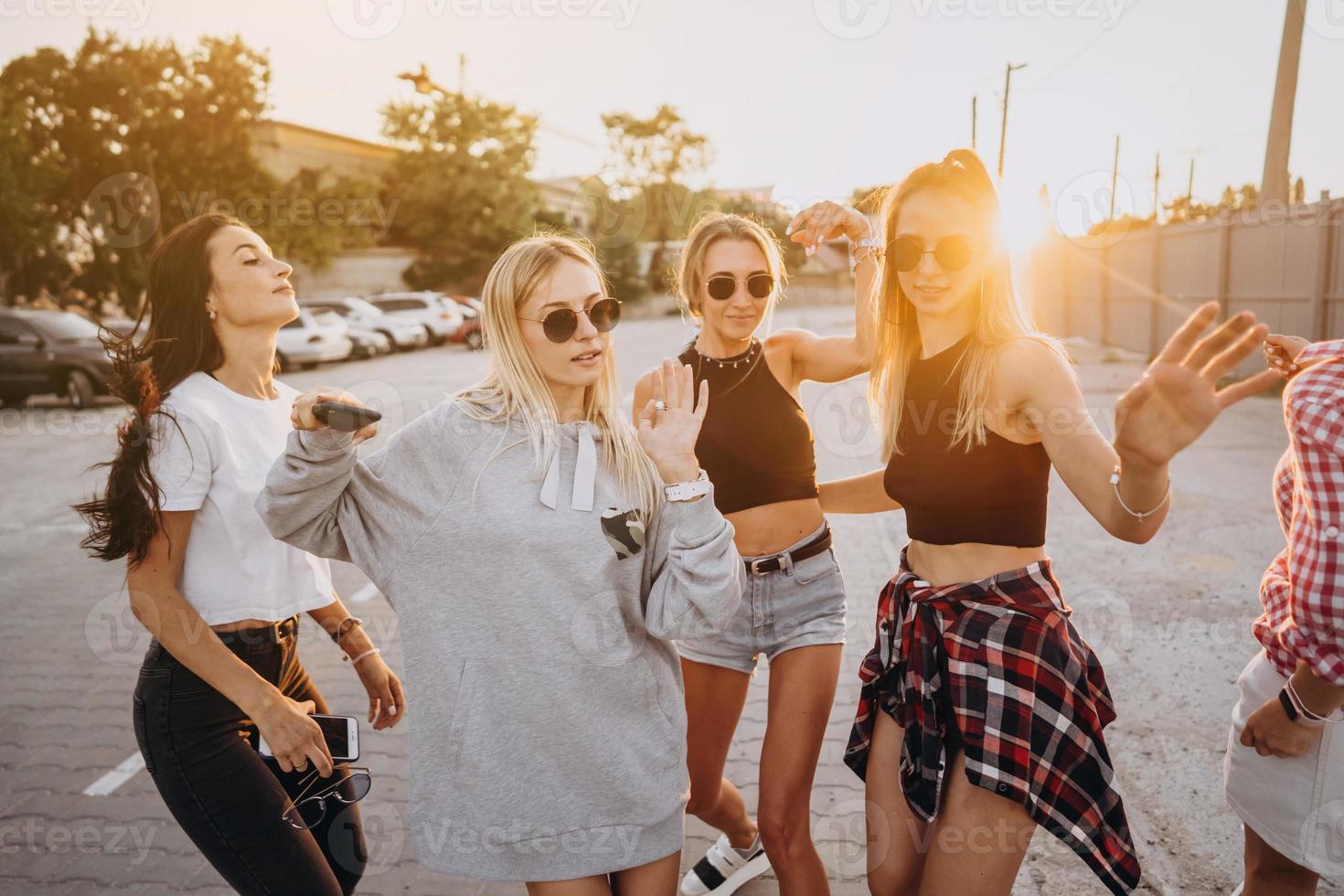 Four young women dance in a car park photo