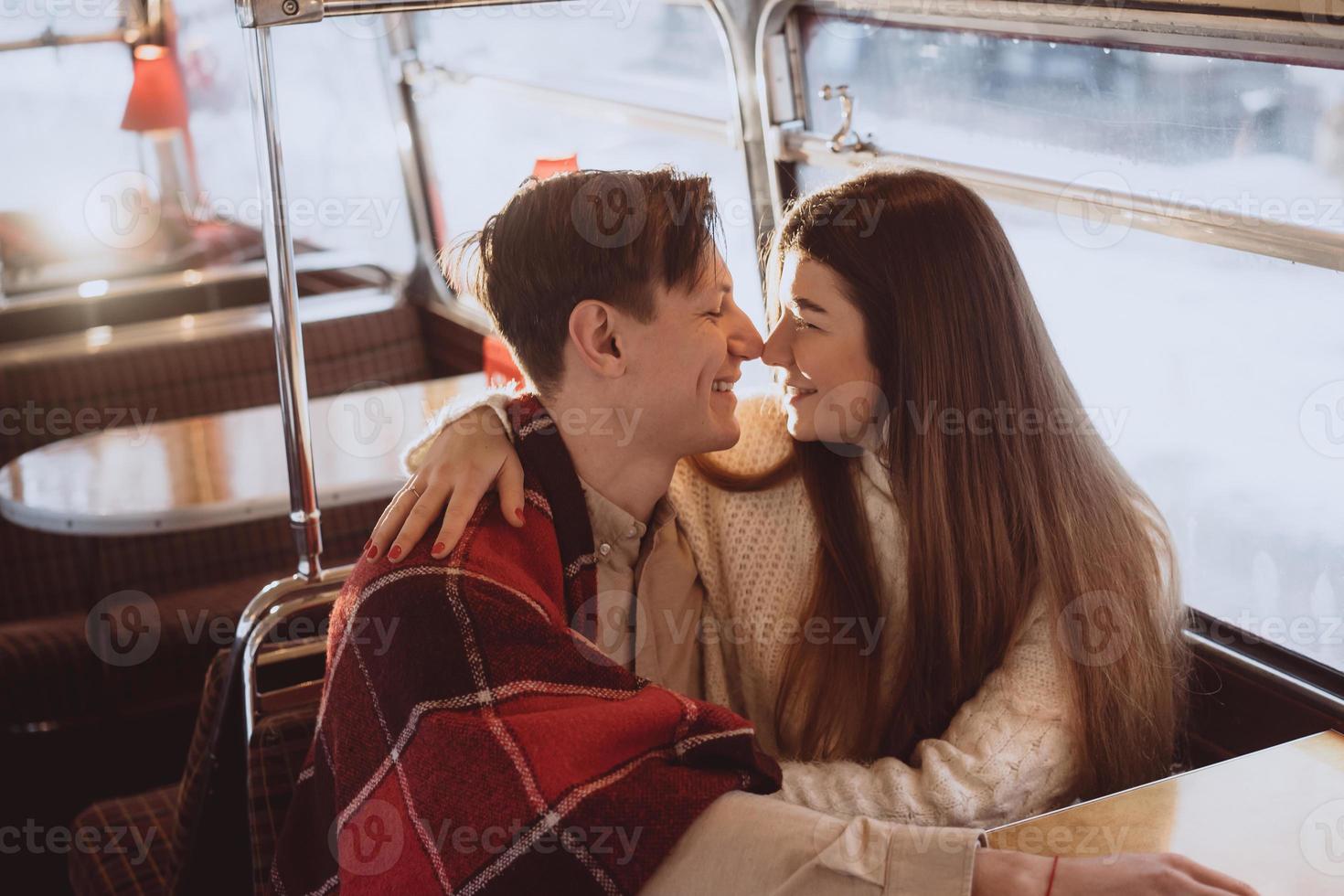 Loving young couple in winter time sitting in a cafe photo