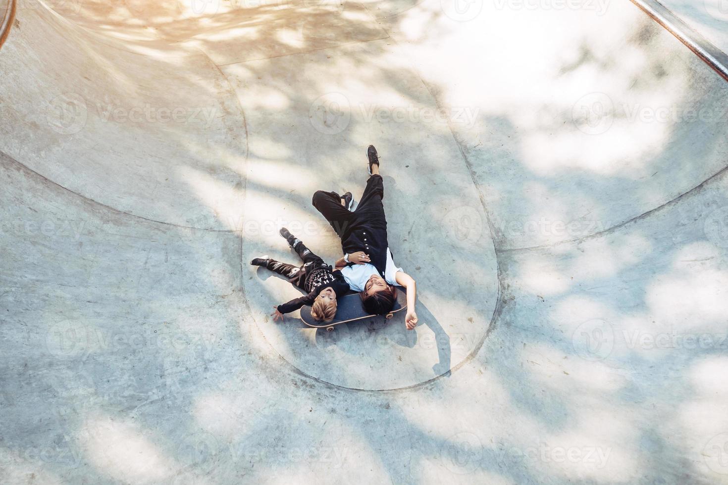 Beautiful young hipster mom and little son at the skatepark photo