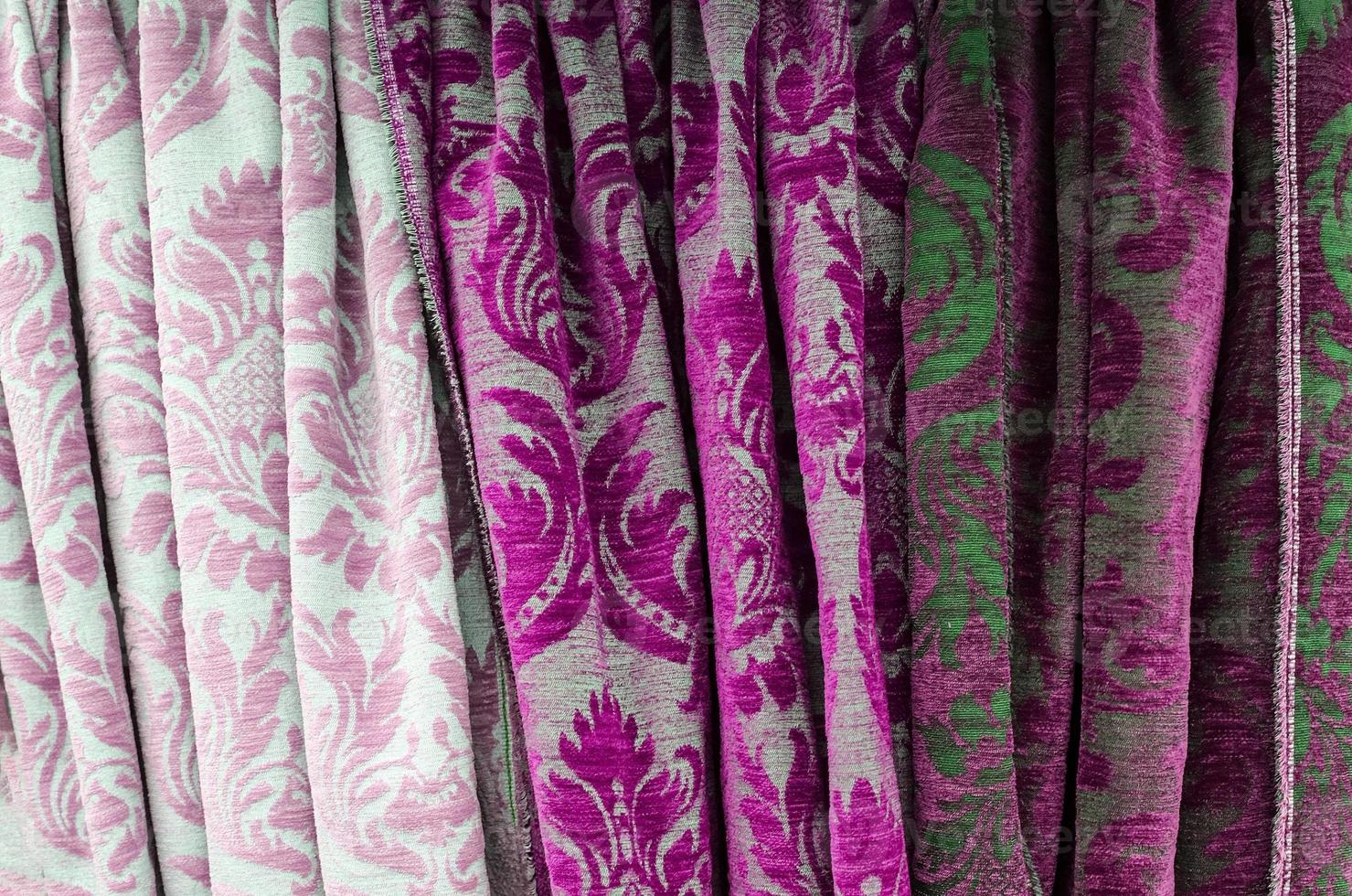 Detailed close up view on samples of cloth and fabrics in different colors found at a fabrics market photo