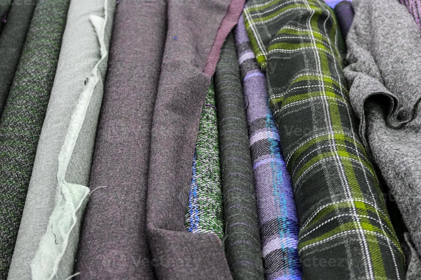 Detailed close up view on samples of cloth and fabrics in different colors found at a fabrics market photo