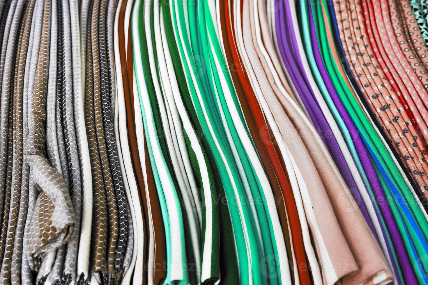 Detailed close up view on samples of cloth and fabrics in different colors found at a fabrics market photo