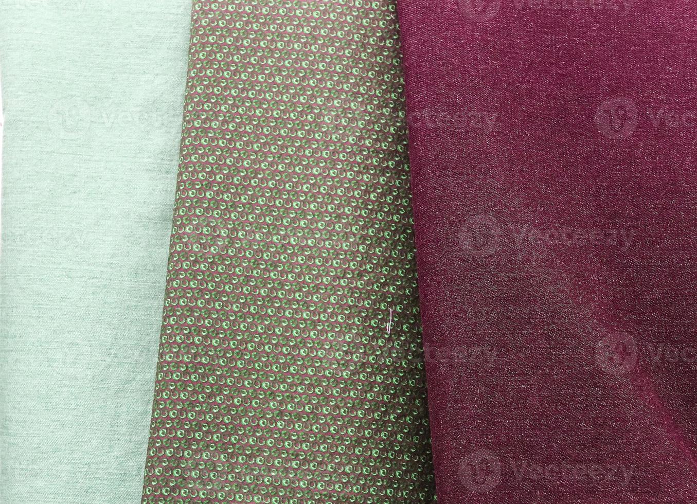 Detailed close up view on samples of cloth and fabrics in different colors found at a fabrics market photo