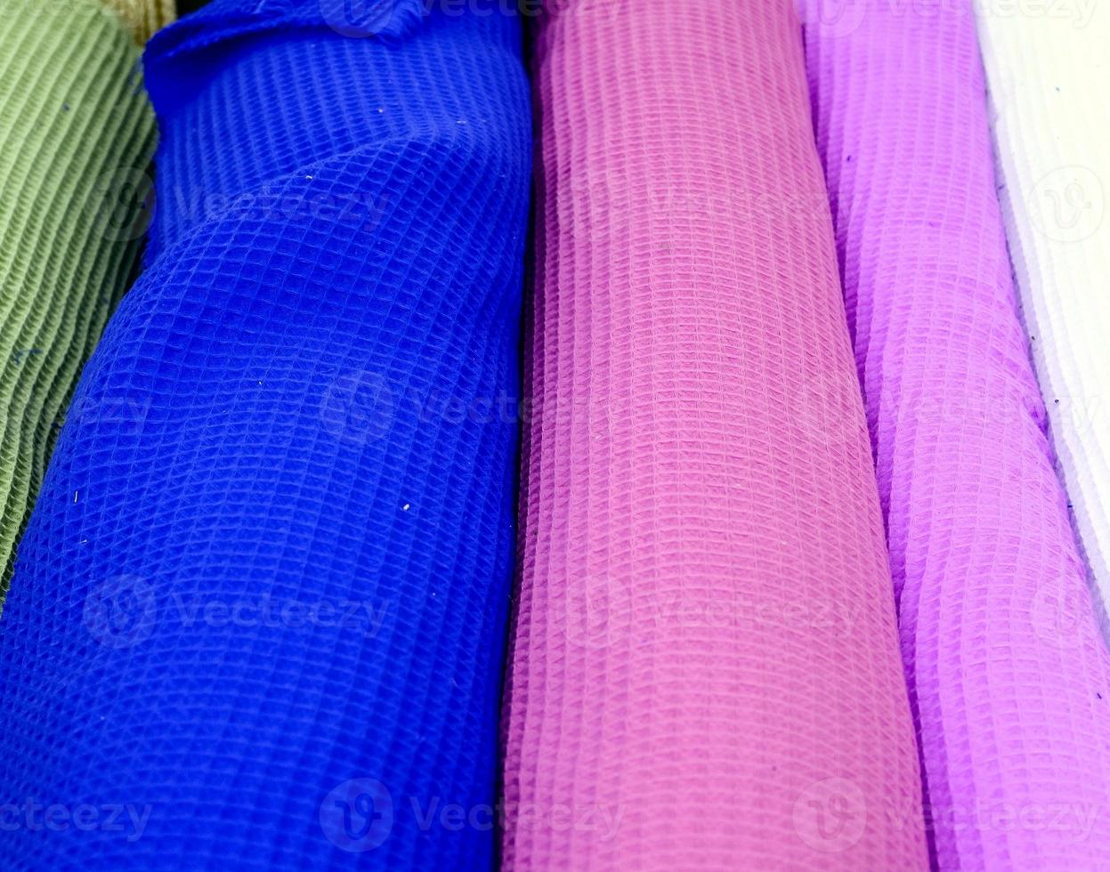 Detailed close up view on samples of cloth and fabrics in different colors found at a fabrics market photo