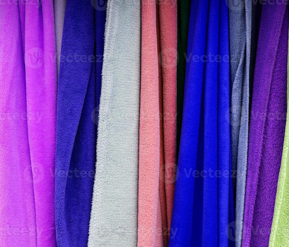 Detailed close up view on samples of cloth and fabrics in different colors found at a fabrics market photo