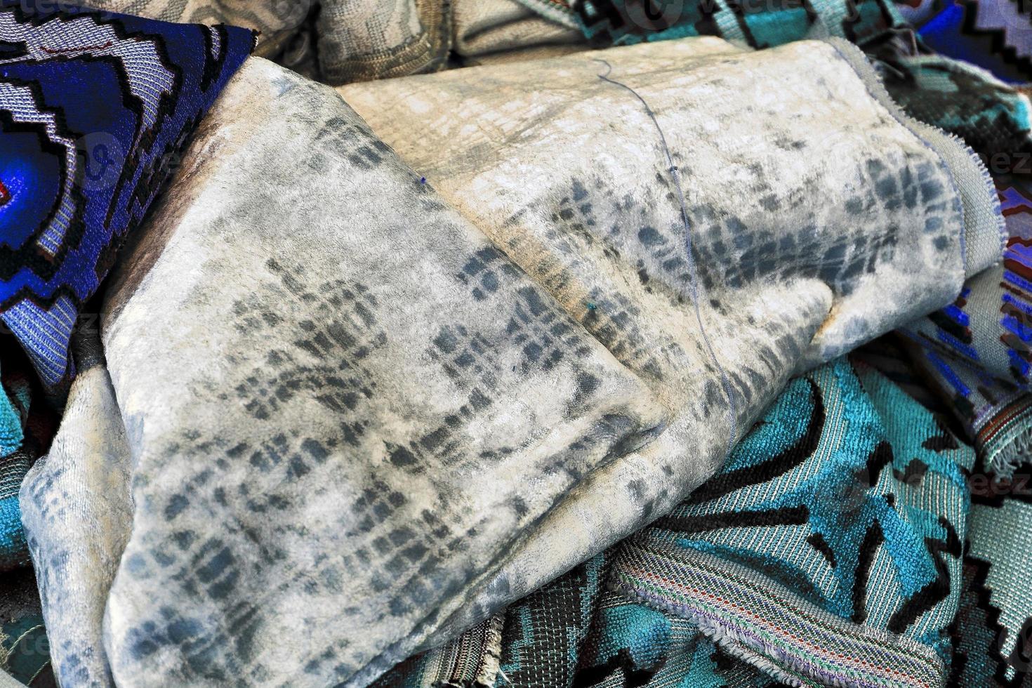 Detailed close up view on samples of cloth and fabrics in different colors found at a fabrics market photo