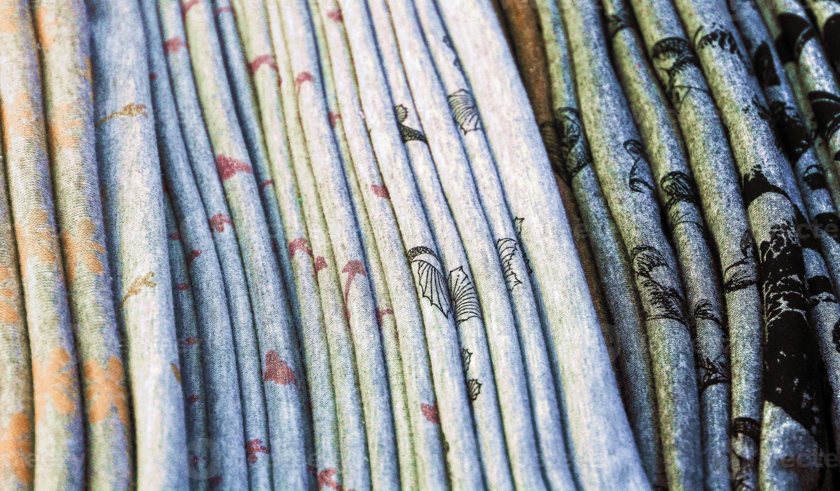 Detailed close up view on samples of cloth and fabrics in different colors found at a fabrics market photo