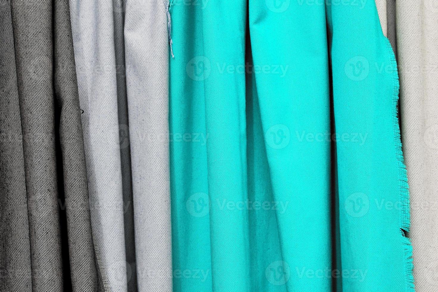 Detailed close up view on samples of cloth and fabrics in different colors found at a fabrics market photo