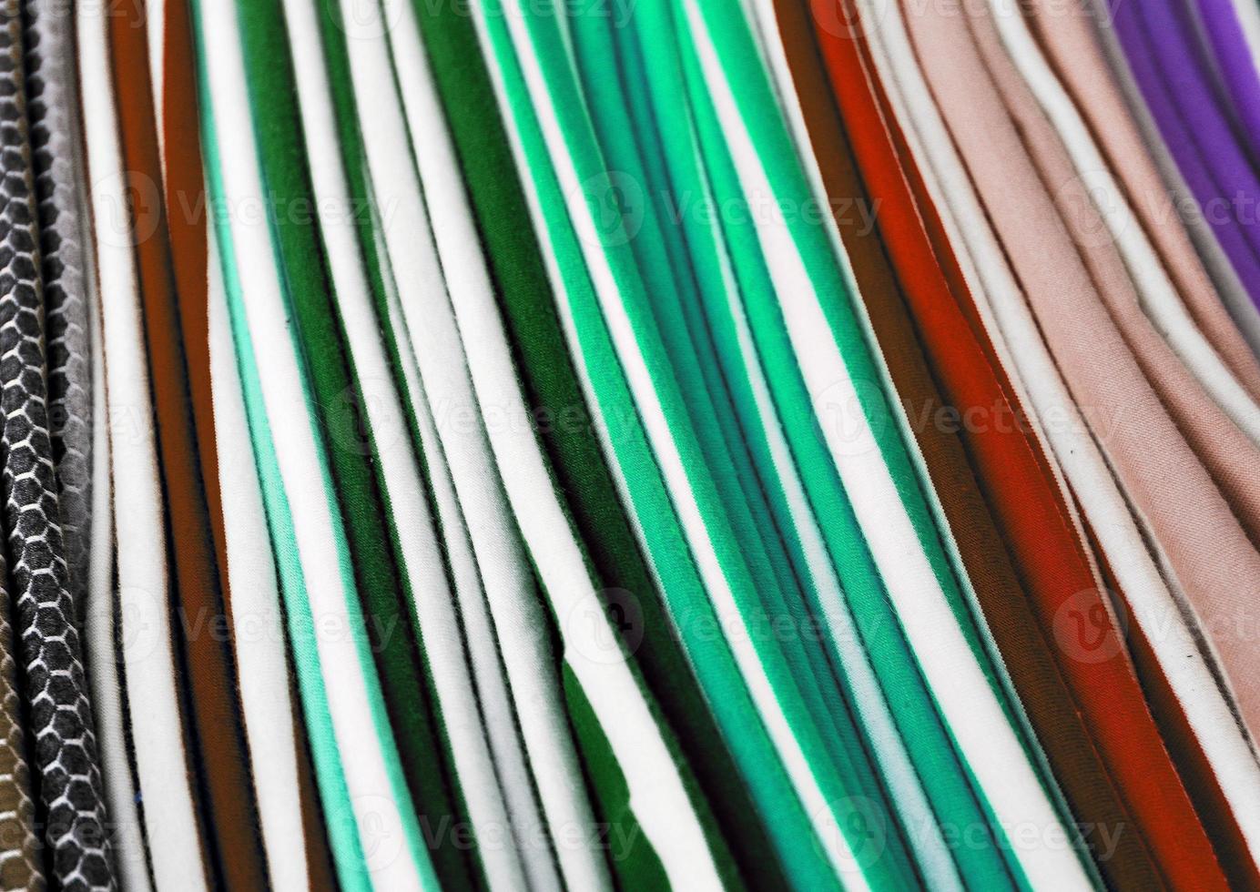 Detailed close up view on samples of cloth and fabrics in different colors found at a fabrics market photo
