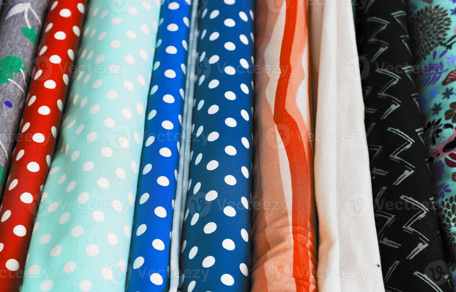 Detailed close up view on samples of cloth and fabrics in different colors found at a fabrics market photo