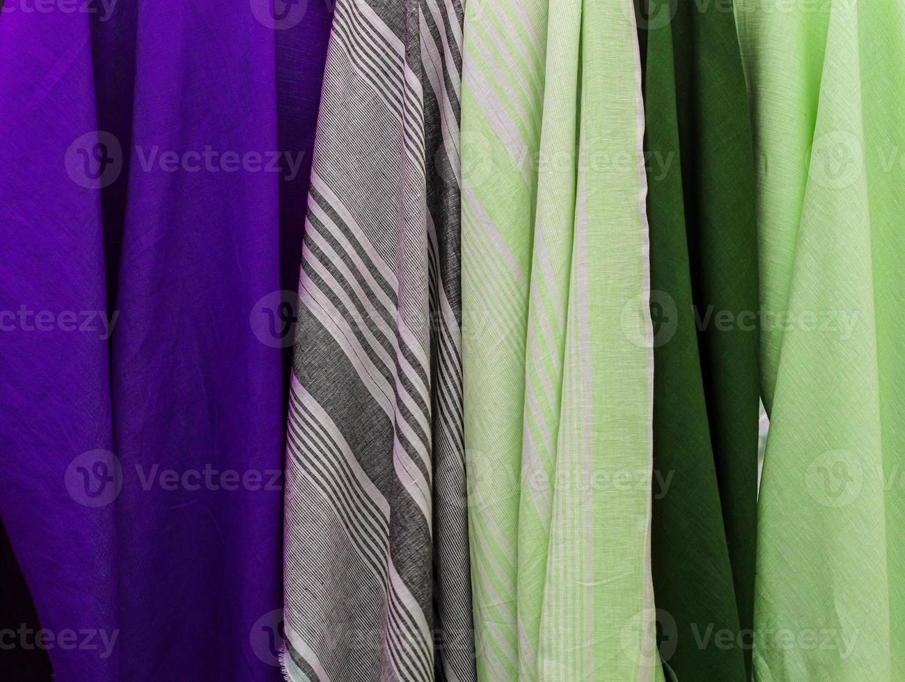 Detailed close up view on samples of cloth and fabrics in different colors found at a fabrics market photo