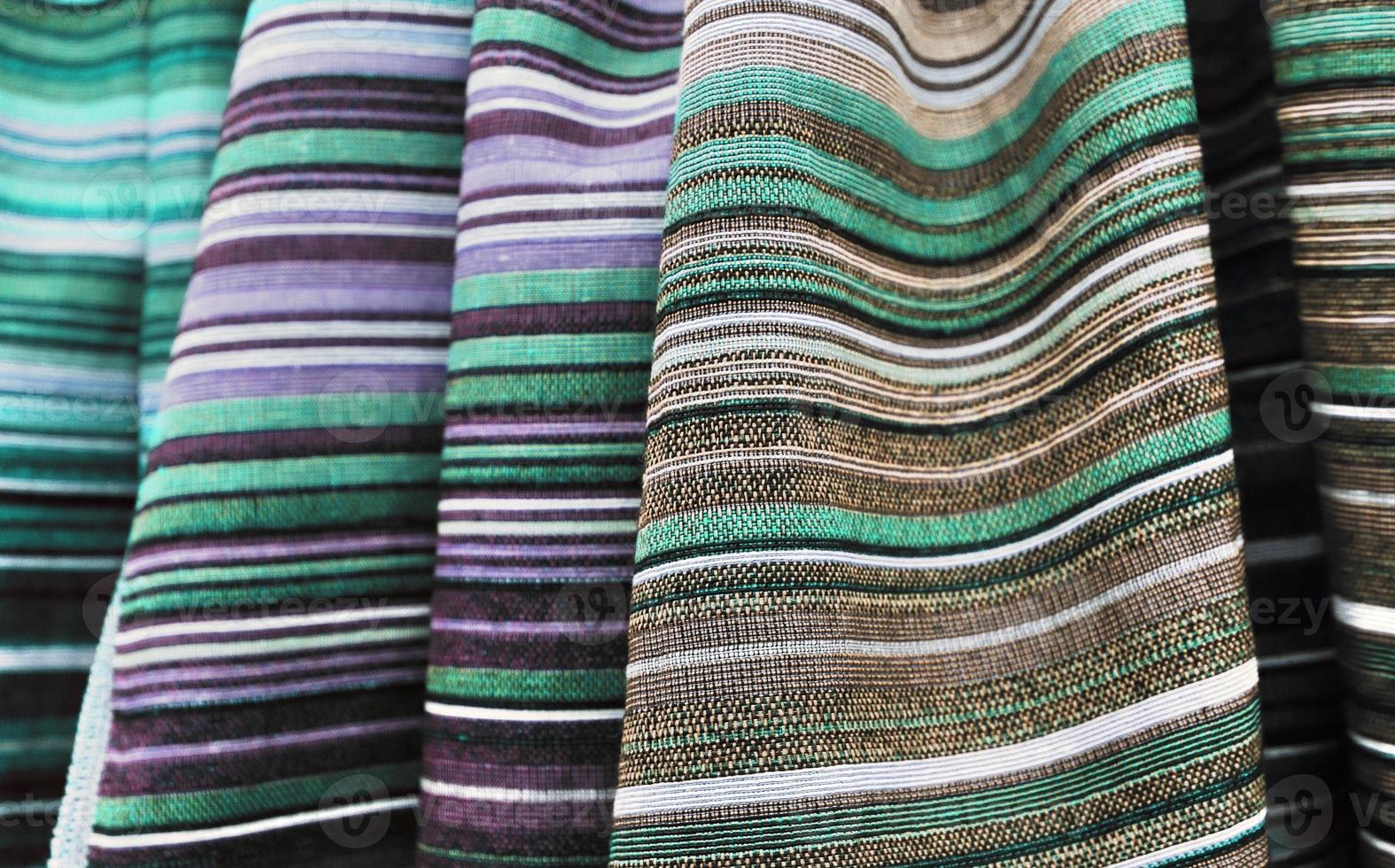 Detailed close up view on samples of cloth and fabrics in different colors found at a fabrics market photo
