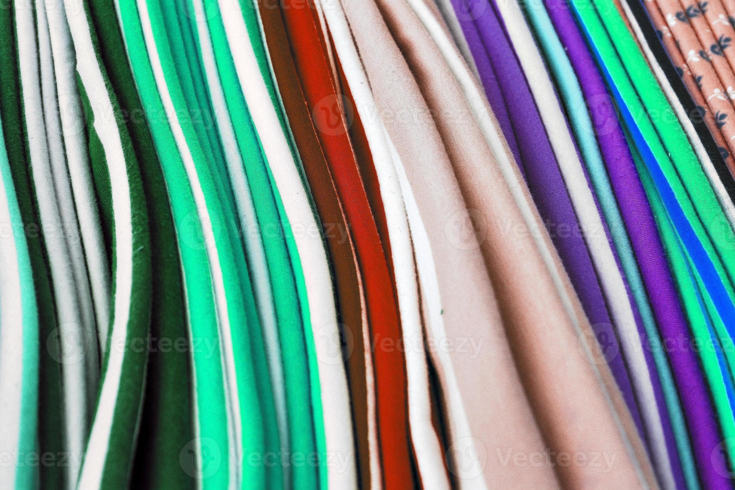 Detailed close up view on samples of cloth and fabrics in different colors found at a fabrics market photo