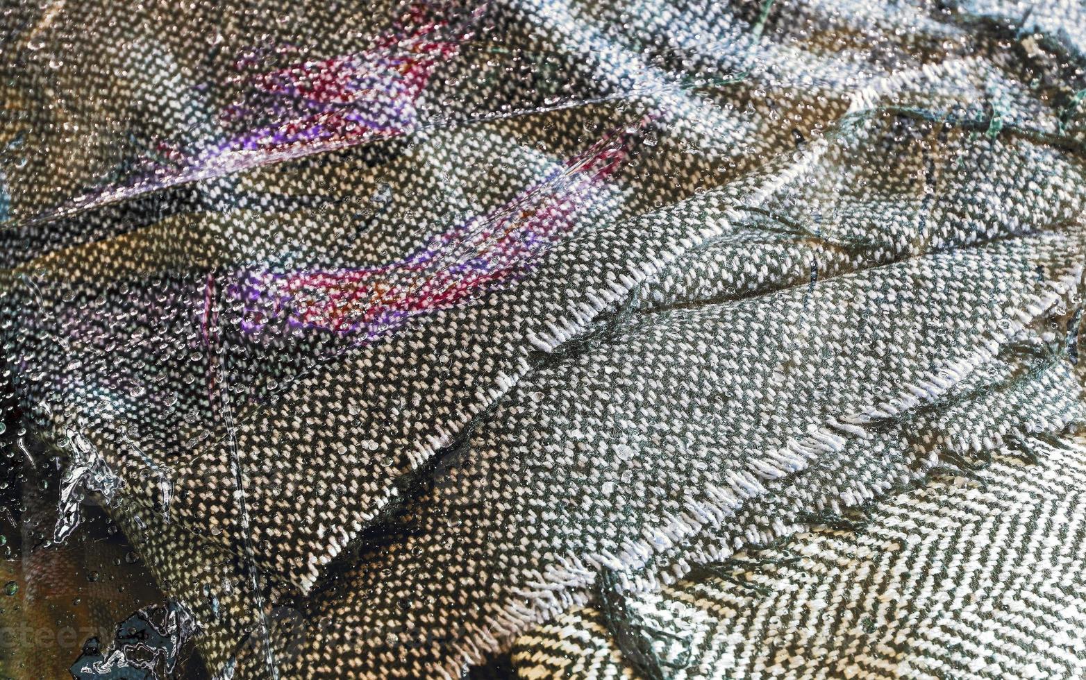 Detailed close up view on samples of cloth and fabrics in different colors found at a fabrics market photo