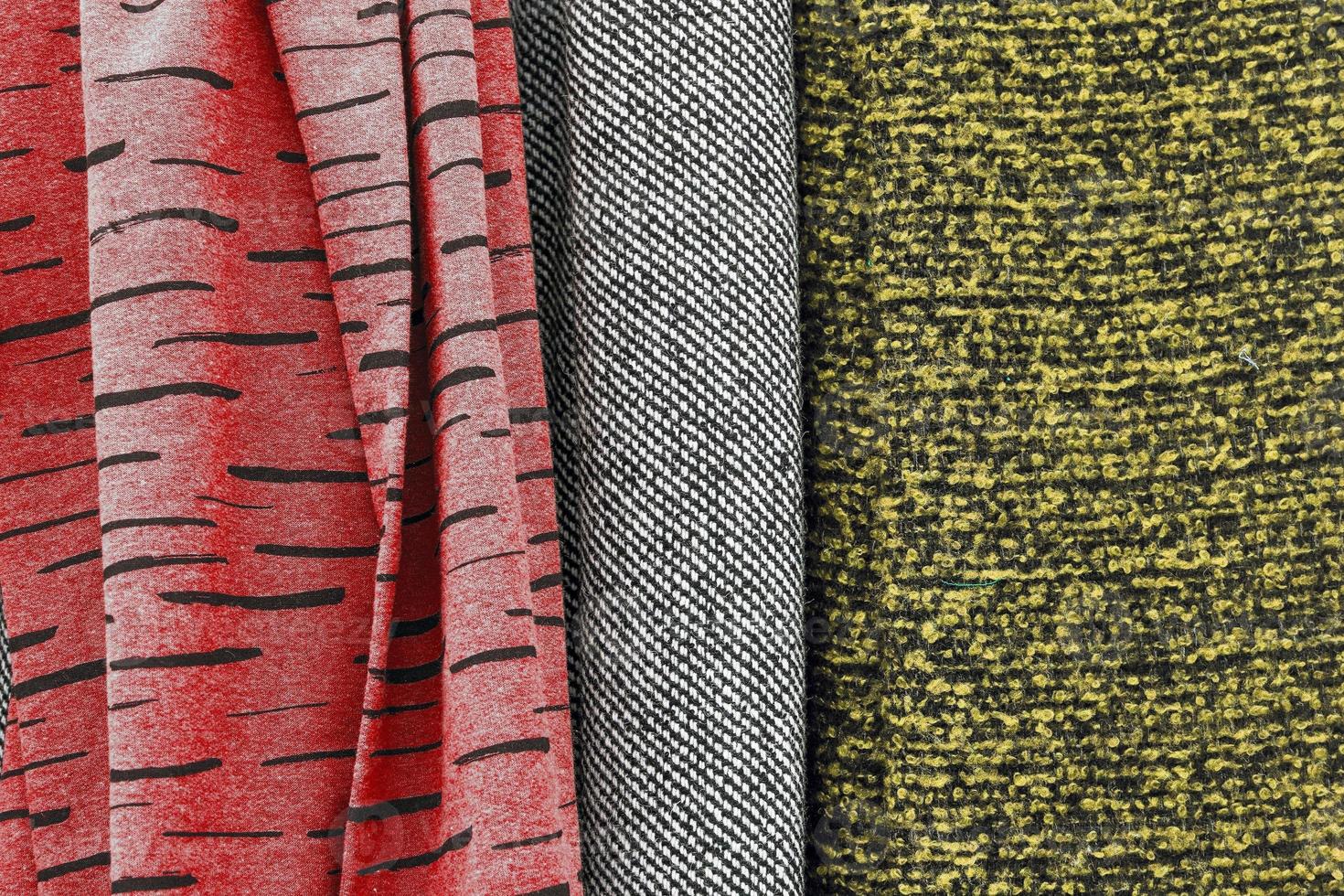 Detailed close up view on samples of cloth and fabrics in different colors found at a fabrics market photo