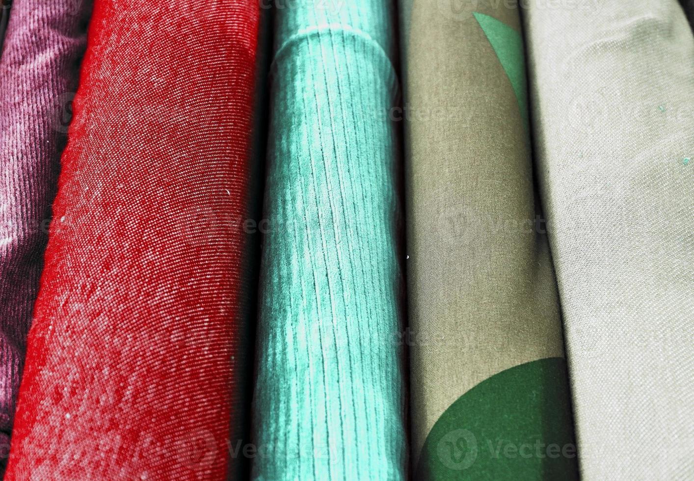 Detailed close up view on samples of cloth and fabrics in different colors found at a fabrics market photo