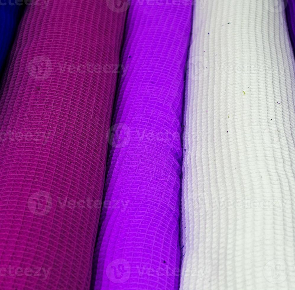 Detailed close up view on samples of cloth and fabrics in different colors found at a fabrics market photo