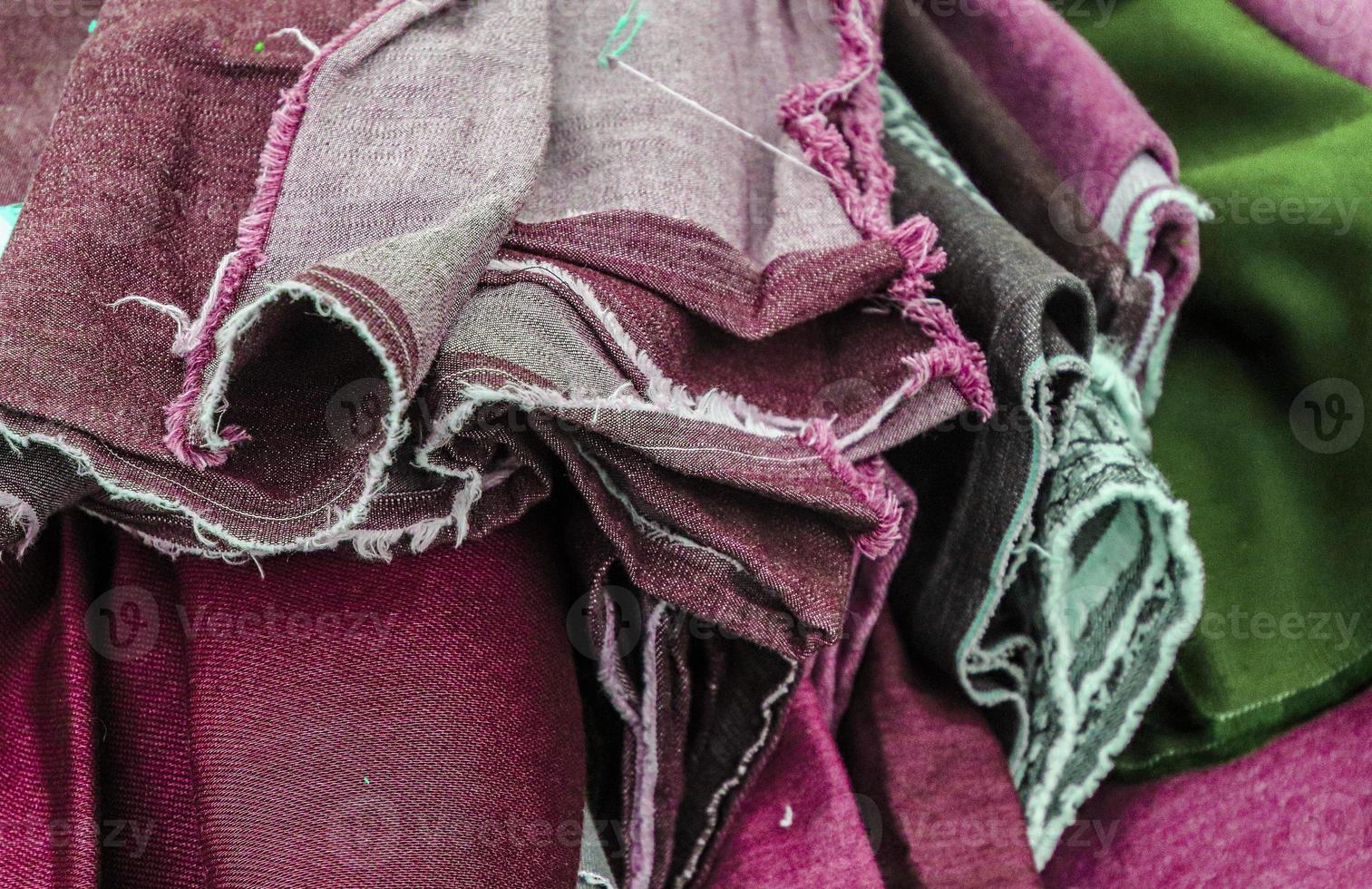 Detailed close up view on samples of cloth and fabrics in different colors found at a fabrics market photo