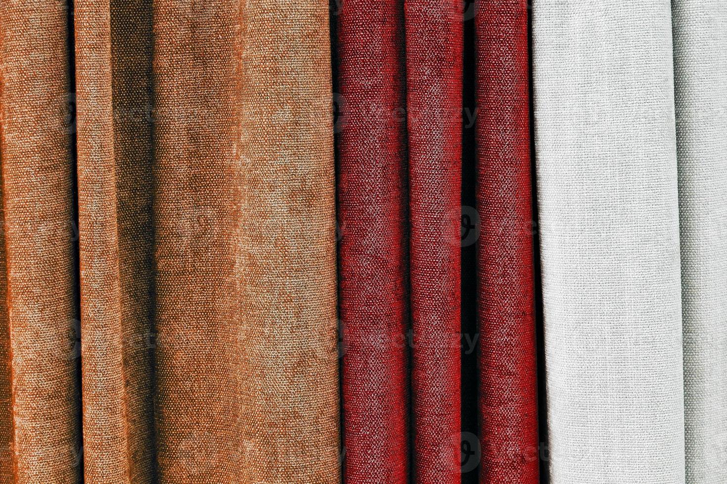 Detailed close up view on samples of cloth and fabrics in different colors found at a fabrics market photo