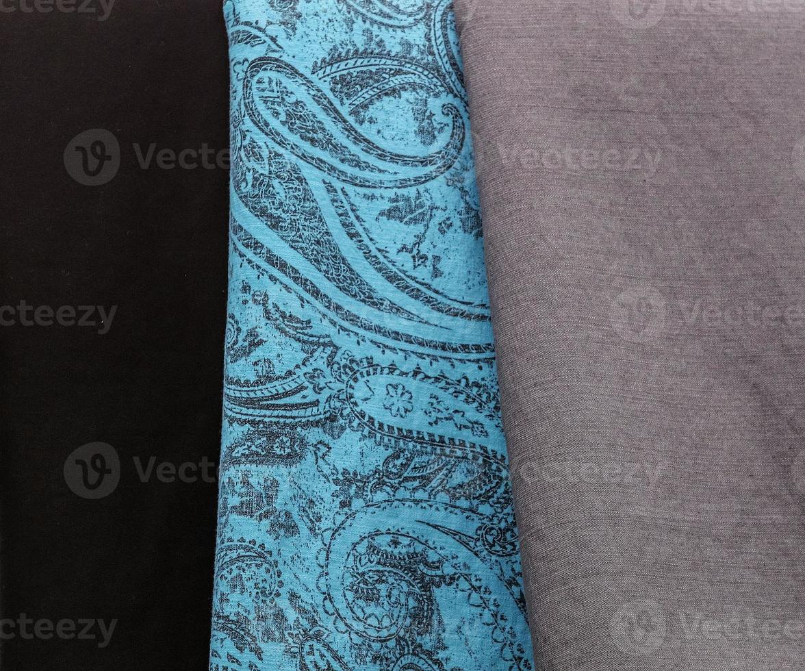 Detailed close up view on samples of cloth and fabrics in different colors found at a fabrics market photo