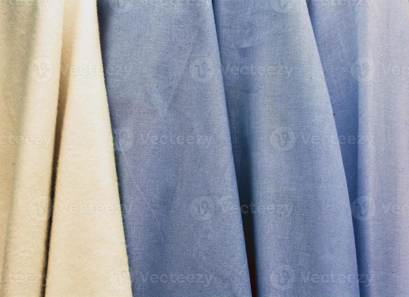 Detailed close up view on samples of cloth and fabrics in different colors found at a fabrics market photo