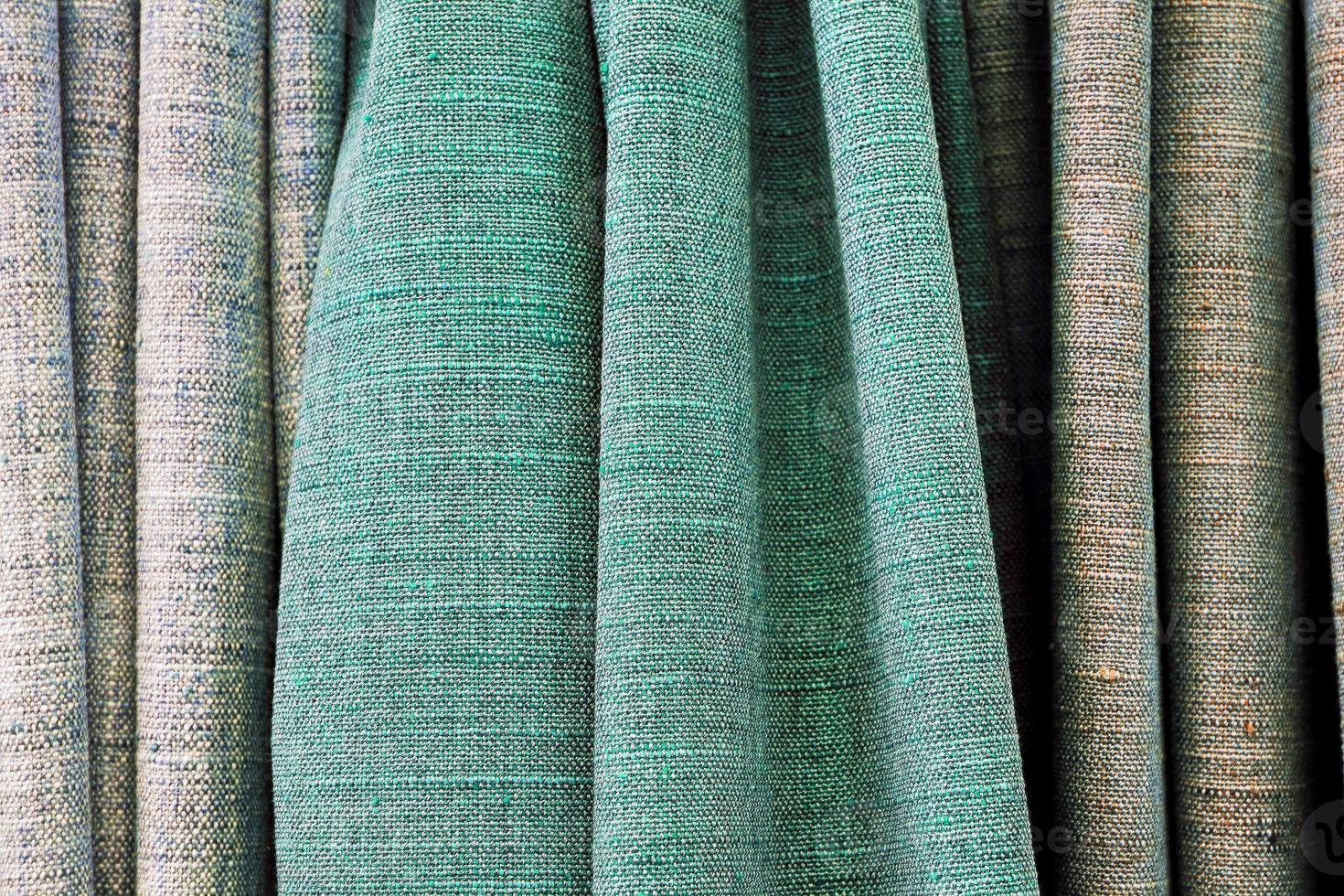 Detailed close up view on samples of cloth and fabrics in different colors found at a fabrics market photo
