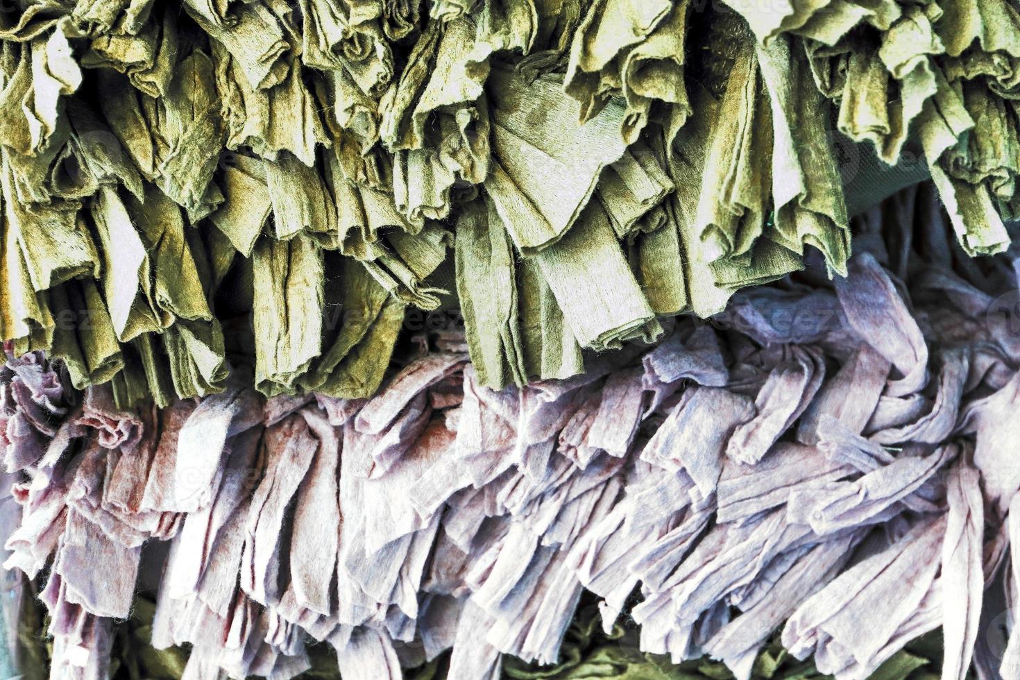 Detailed close up view on samples of cloth and fabrics in different colors found at a fabrics market photo