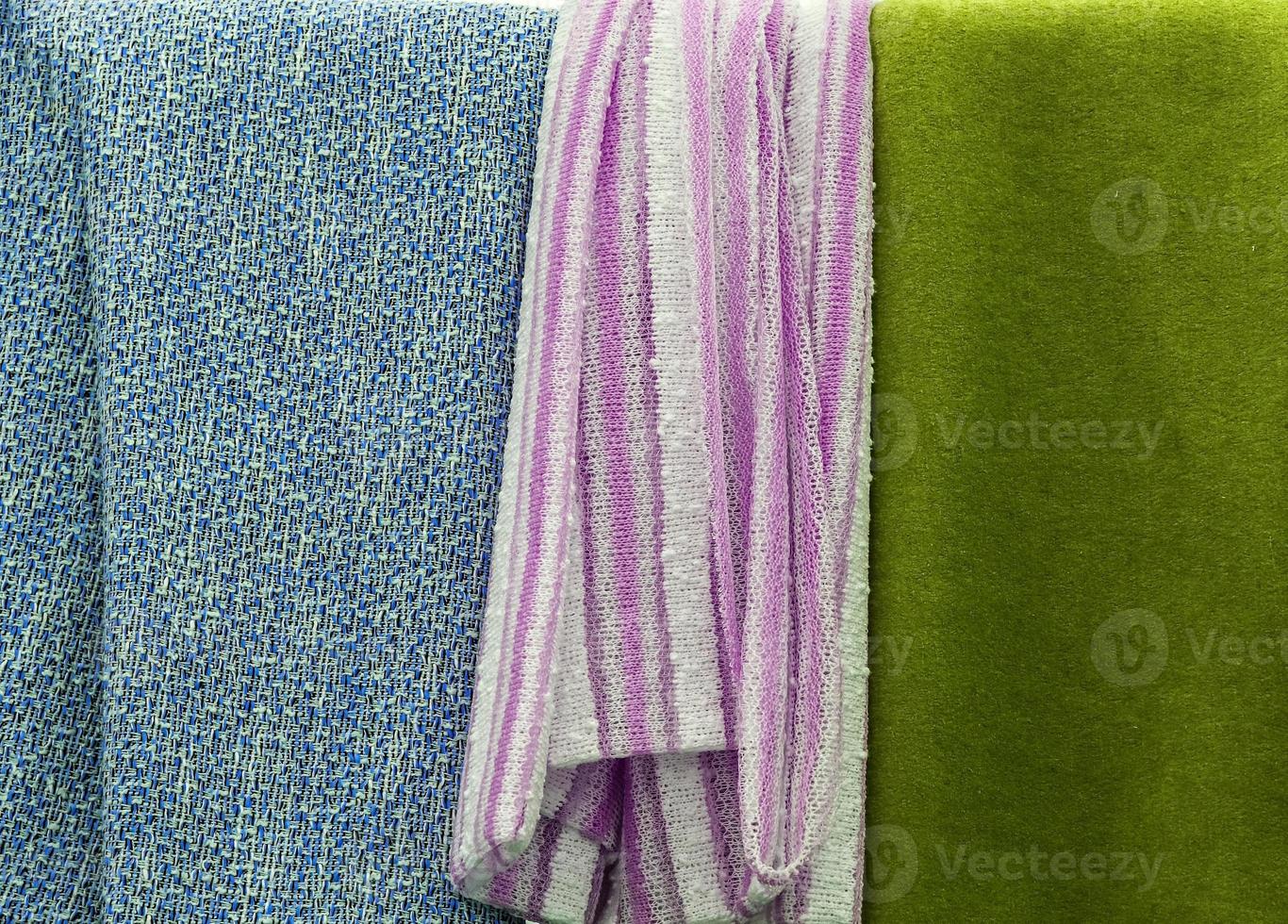 Detailed close up view on samples of cloth and fabrics in different colors found at a fabrics market photo