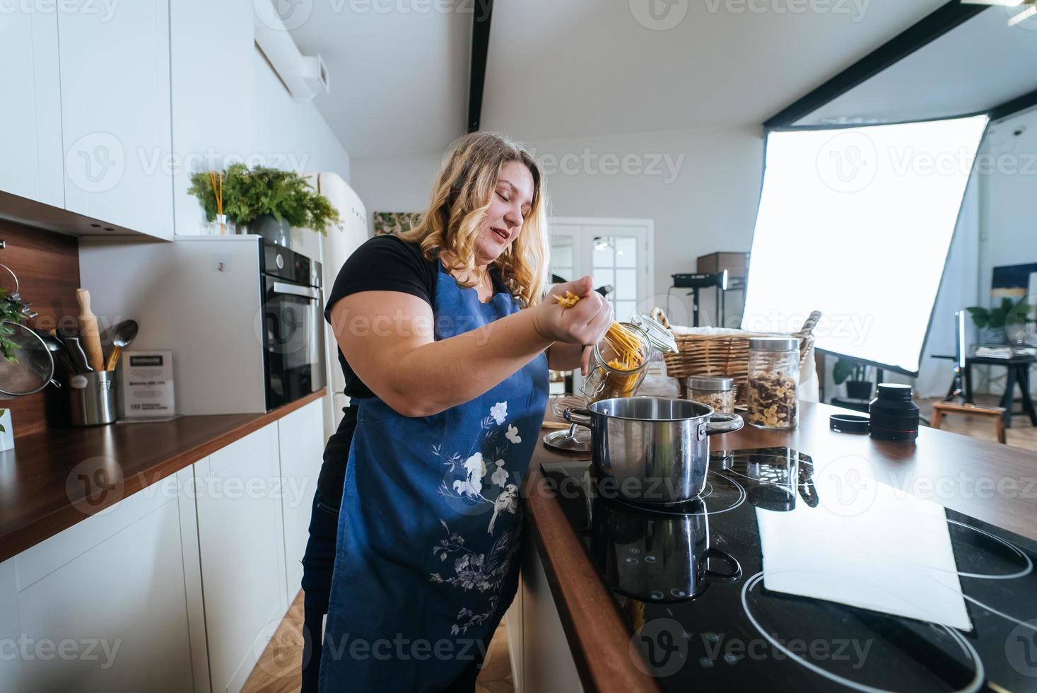 Cooking - Woman in modern kitchen, preparing spaghetti photo