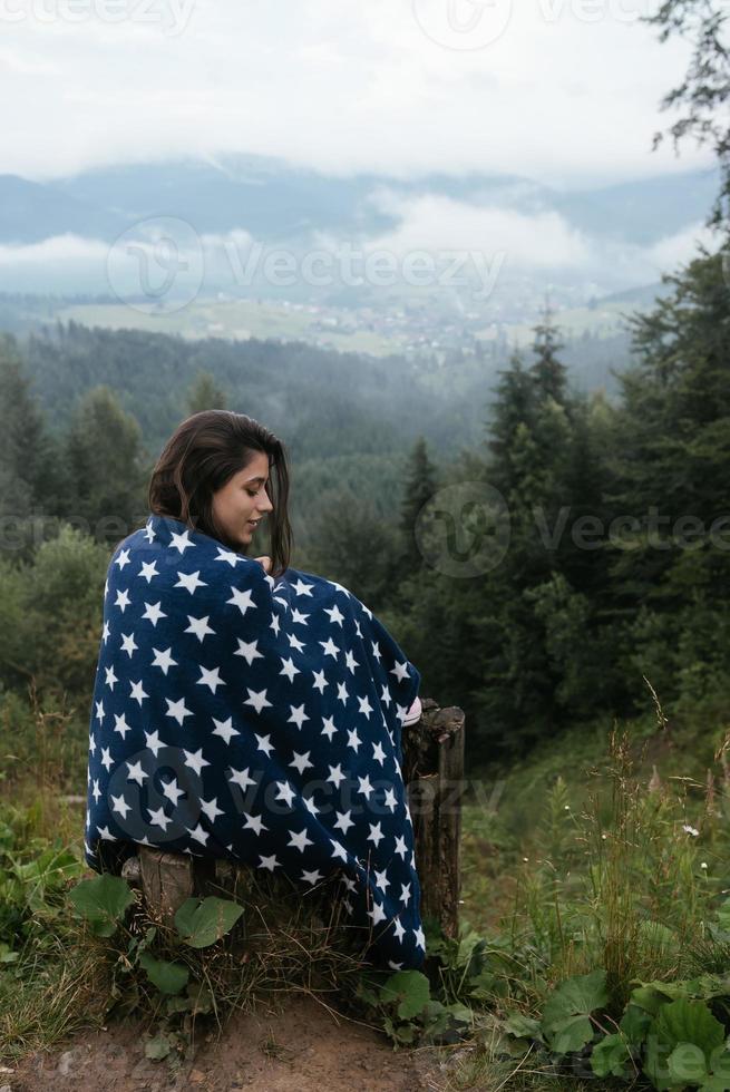 Woman on top of a hill, against the background of a valley photo