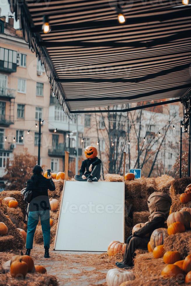 Guy with a  pumpkin head poses for the camera photo