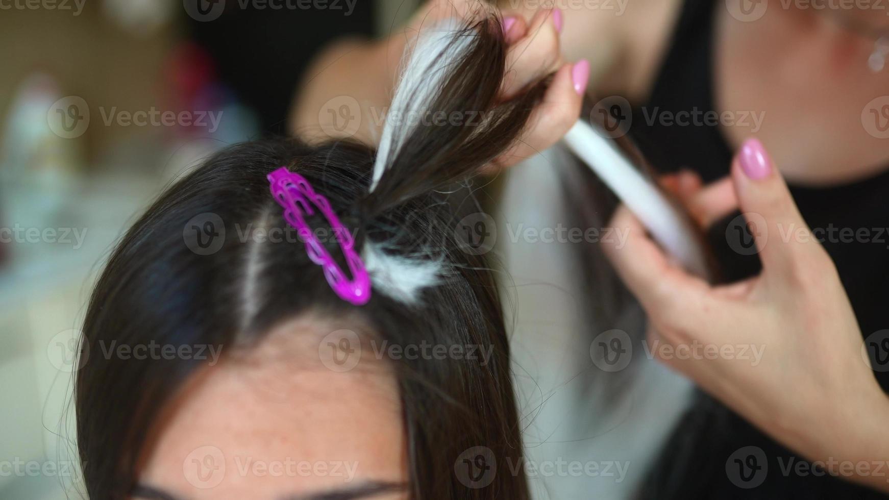 Process of braiding. Master weaves braids on head in a beauty salon, close up photo