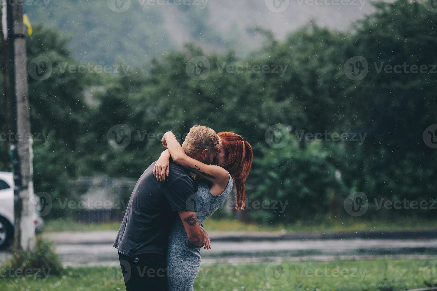 beautiful couple hugging in the rain photo