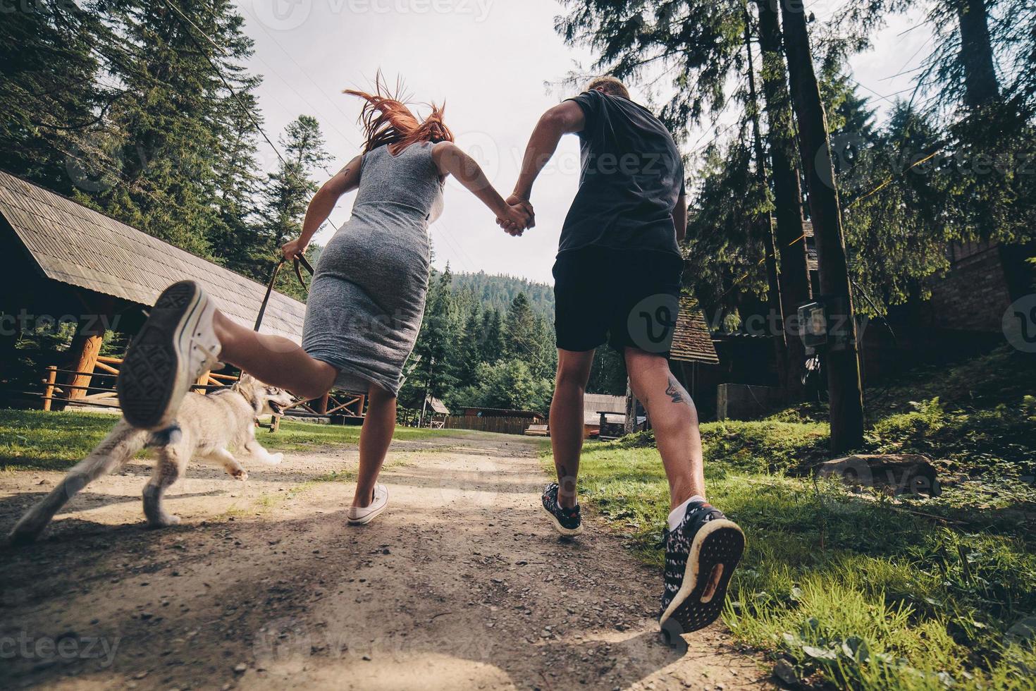 couple runs on road in the nature with dog photo